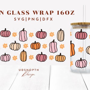 May include: A 16 oz glass can wrap with a pattern of pink, orange, and cream pumpkins and orange flowers. The text "CAN GLASS WRAP 160Z" and "SVG|PNG|DFX" is at the top of the image. The text "UDSHOPTH Design" is at the bottom of the image.
