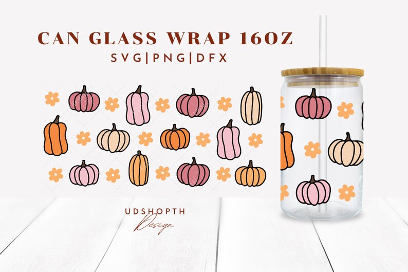 May include: A 16 oz glass can wrap with a pattern of pink, orange, and cream pumpkins and orange flowers. The text "CAN GLASS WRAP 160Z" and "SVG|PNG|DFX" is at the top of the image. The text "UDSHOPTH Design" is at the bottom of the image.
