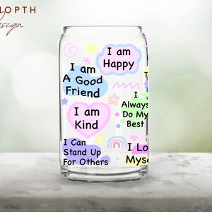 May include: A clear glass can with colorful text and illustrations. The text includes positive affirmations such as "I am a good friend", "I am kind", "I am happy", "I always do my best", "I can stand up for others", and "I love myself".
