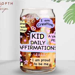 May include: A glass can with a brown liquid inside. The can has colorful stickers with positive affirmations for kids, such as "I am Creative" and "I am proud to be me".