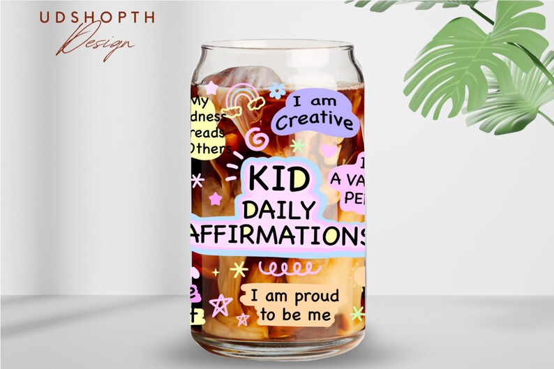 May include: A glass can with a brown liquid inside. The can has colorful stickers with positive affirmations for kids, such as "I am Creative" and "I am proud to be me".