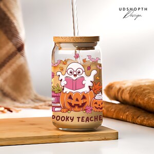 Pu&ograve; includere: Un barattolo di vetro con un coperchio di legno e un design a tema Halloween. Il barattolo presenta un fantasma dei cartoni animati che legge un libro, zucche e il testo "Spooky Teacher".