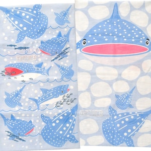 May include: A blue and white fabric with a repeating pattern of whale sharks. The whale sharks are swimming in a light blue ocean with white bubbles. The fabric has the text "Oceanarium" printed on it.