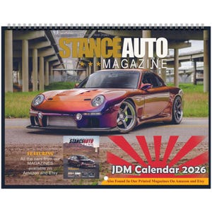 May include: A spiral-bound calendar featuring a vibrant orange and purple sports car. The cover reads "STANCE AUTO MAGAZINE" with "JDM Calendar 2026" below. Additional text mentions magazines available on Amazon and Etsy.