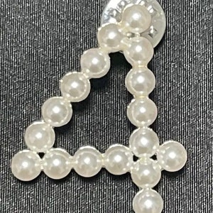 May include: A white pearl number four pin, made of small round pearls, with a silver backing.