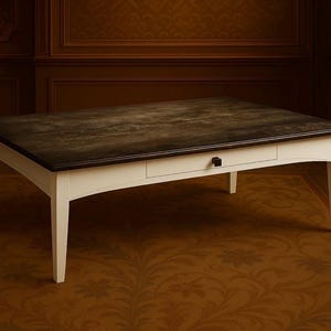 May include: A rectangular coffee table with a dark brown, textured top and a white base. The table has a single drawer with a black handle. The legs are slightly curved. The table is approximately 48 inches long and 24 inches wide.