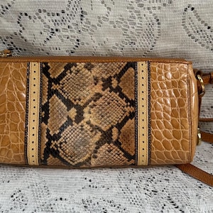 May include: A rectangular crossbody bag featuring a central panel with a brown and black snakeskin pattern, flanked by two vertical cream-colored strips with perforated detailing, and side panels with a tan embossed crocodile skin texture.