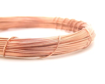 May include: A close-up of a coil of copper wire. The wire is a warm, reddish-brown color and is tightly wound together.