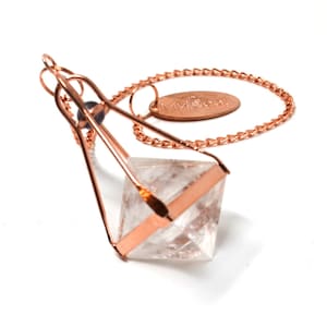 May include: A clear quartz crystal pendulum with a rose gold cage and chain. The chain has a rose gold tag with the text "MyDoodal" on it.