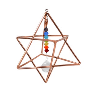 May include: A copper wire star of David geometric shape with a clear crystal hanging from the center and a rainbow of chakra beads hanging from the top.