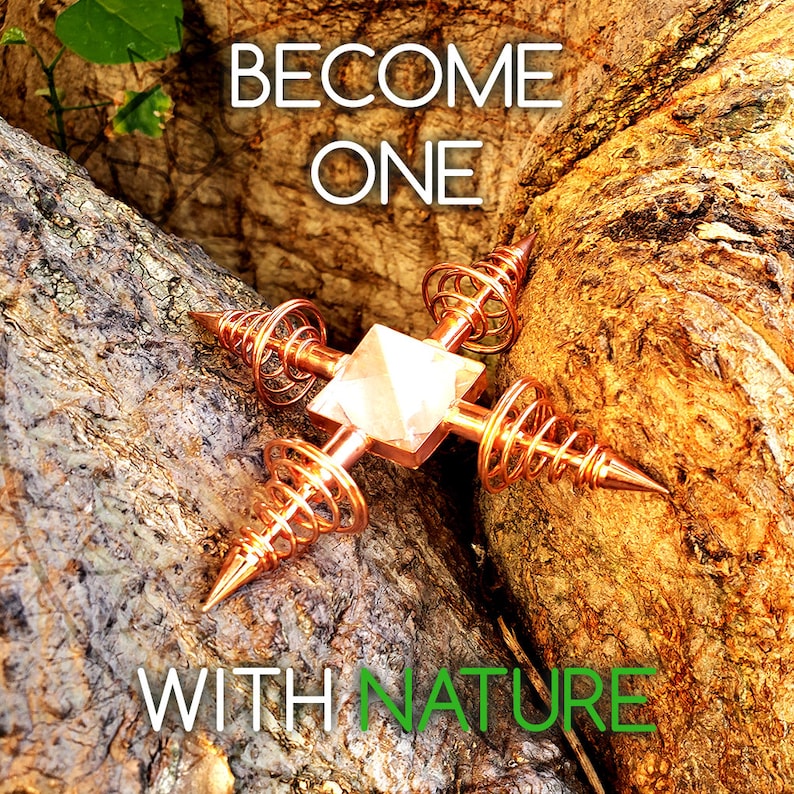 May include: A copper and rose quartz crystal grid with the words "Become One With Nature" on a wooden background.