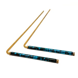 May include: Two brass rods with blue and black marbled epoxy handles. The rods are bent at a 90-degree angle.