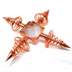 May include: A copper orgonite pyramid with four copper coils and a clear quartz crystal in the center.
