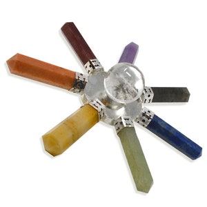 May include: A seven-pointed crystal chakra set with a clear quartz crystal in the center. The points are made of red, orange, yellow, green, blue, indigo, and violet crystals.