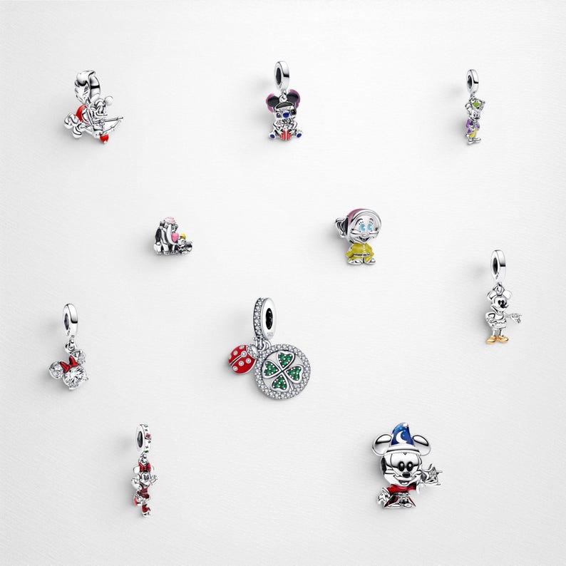 May include: A collection of ten silver charms featuring various designs including a ladybird with a four-leaf clover, a wizard mouse, a mouse with a bow, a dwarf, and other character-themed figures with colourful enamel and crystal accents.