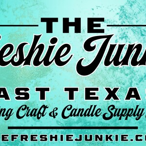 May include: A rectangular sign with a textured turquoise background featuring the black text THE Freshie Junkie, EAST TEXAS' Leading Craft & Candle Supply Store, and the website address THEFRESHIEJUNKIE.COM centred with horizontal black lines.