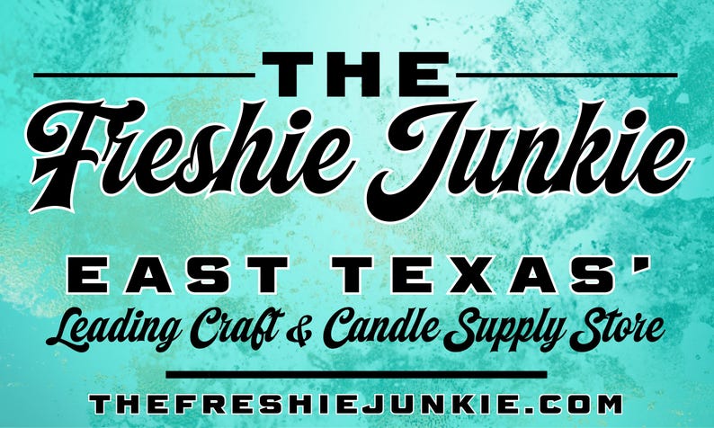 May include: A rectangular sign with a textured turquoise background featuring the black text THE Freshie Junkie, EAST TEXAS' Leading Craft & Candle Supply Store, and the website address THEFRESHIEJUNKIE.COM centred with horizontal black lines.