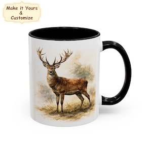 Peut inclure: Un mug en céramique blanche avec une anse et un bord intérieur noirs. L'extérieur présente une illustration style aquarelle d'un cerf brun aux grands bois debout dans un champ herbeux. Au-dessus, le texte indique Make it Yours & Customize.