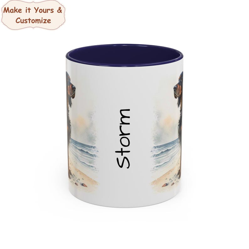 May include: White ceramic mug with a navy blue interior. The mug features a watercolour illustration of a dog on a beach scene. The name "Storm" is printed vertically on the side. The text "Make it Yours & Customize" is in the upper left corner.