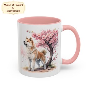 May include: A white ceramic mug with a pink interior and handle, featuring a printed illustration of an Akita dog standing beneath a blooming cherry blossom tree. The text "Make it Yours & Customize" appears in the upper left corner of the image.