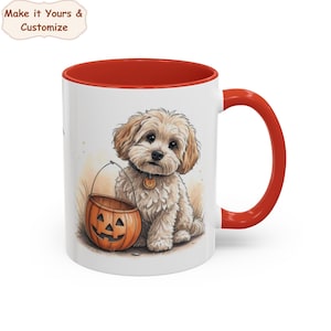 Pode incluir: Uma caneca de cerâmica branca com interior e alça em vermelho brilhante. O exterior apresenta uma ilustração gráfica de um filhote de cachorro castanho claro e peludo sentado ao lado de um balde de abóbora laranja. O texto Make it Yours & Customize é visível.