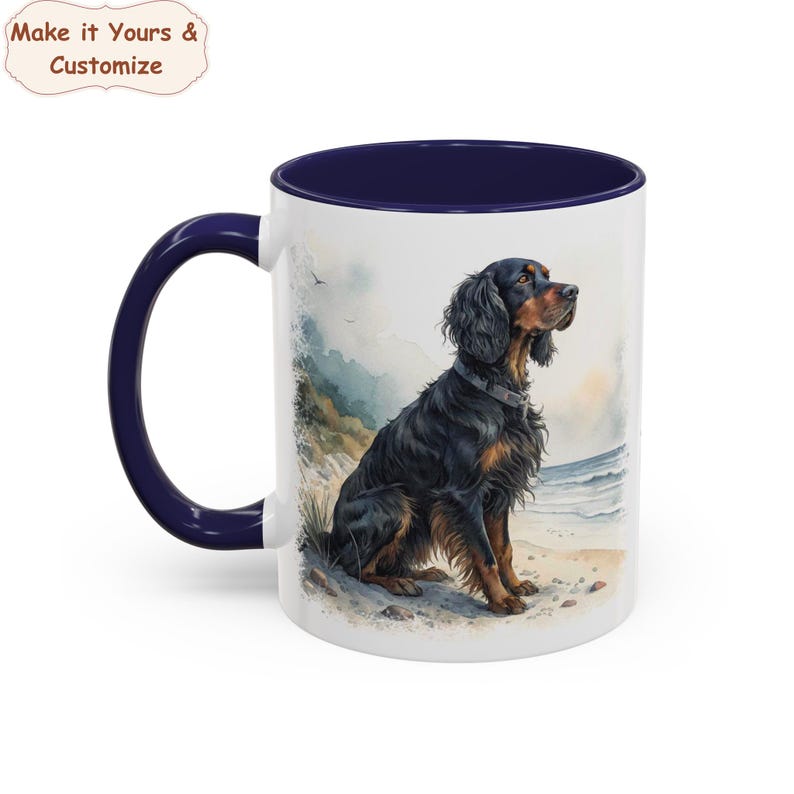 May include: White ceramic mug with a navy blue interior and handle. The mug features a watercolour illustration of a black and brown dog sitting on a beach. The text "Make it Yours & Customize" is in the upper left corner.
