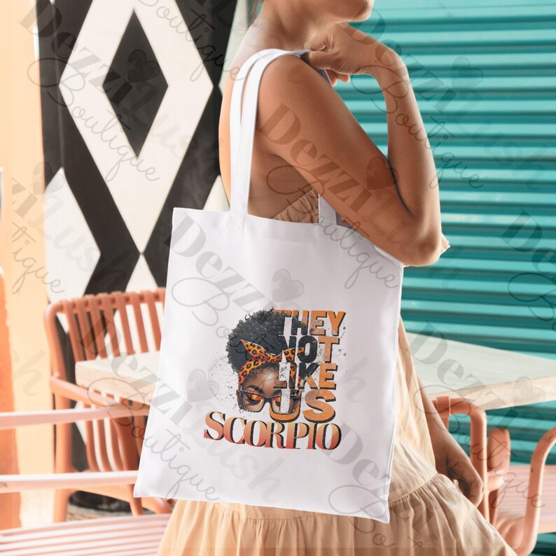 May include: White tote bag with a graphic of a woman with an afro and the text "They Not Like Us Scorpio".