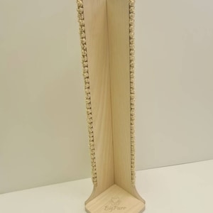 Pu&ograve; includere: Un tiragraffi per gatti in legno con corda di sisal avvolta attorno ai lati. Il palo ha la forma di un angolo e ha una base con il testo "Big Purr" inciso su di esso.