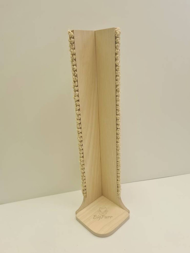 Pu&ograve; includere: Un tiragraffi per gatti in legno con corda di sisal avvolta attorno ai lati. Il palo ha la forma di un angolo e ha una base con il testo "Big Purr" inciso su di esso.