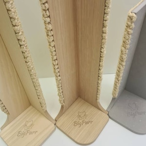 Pu&ograve; includere: Tre tiragraffi per gatti in legno con pali rivestiti in corda di sisal. I pali sono a forma di angolo e hanno una base con il logo "BigPurr" inciso.