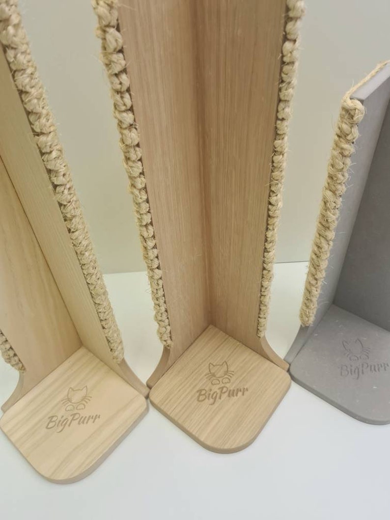 Pu&ograve; includere: Tre tiragraffi per gatti in legno con pali rivestiti in corda di sisal. I pali sono a forma di angolo e hanno una base con il logo "BigPurr" inciso.