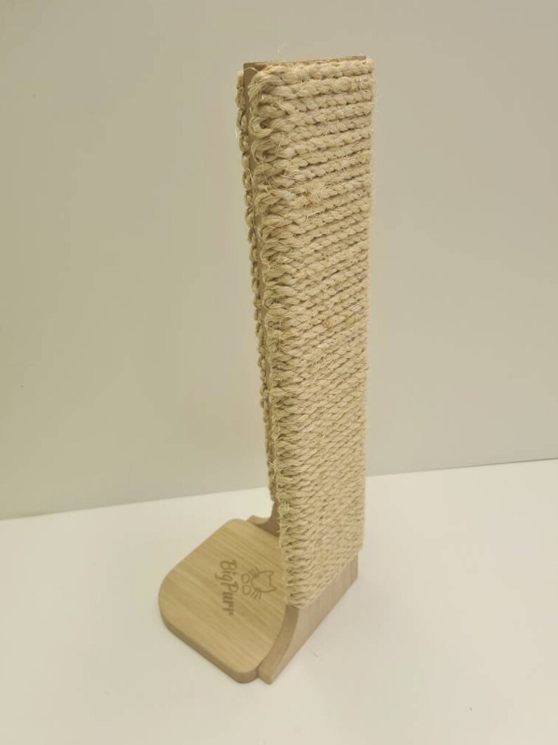 Pu&ograve; includere: Un tiragraffi per gatti beige con una copertura in corda di sisal naturale. Il palo &egrave; in legno e ha una base con il testo "BigPurr" inciso su di esso.