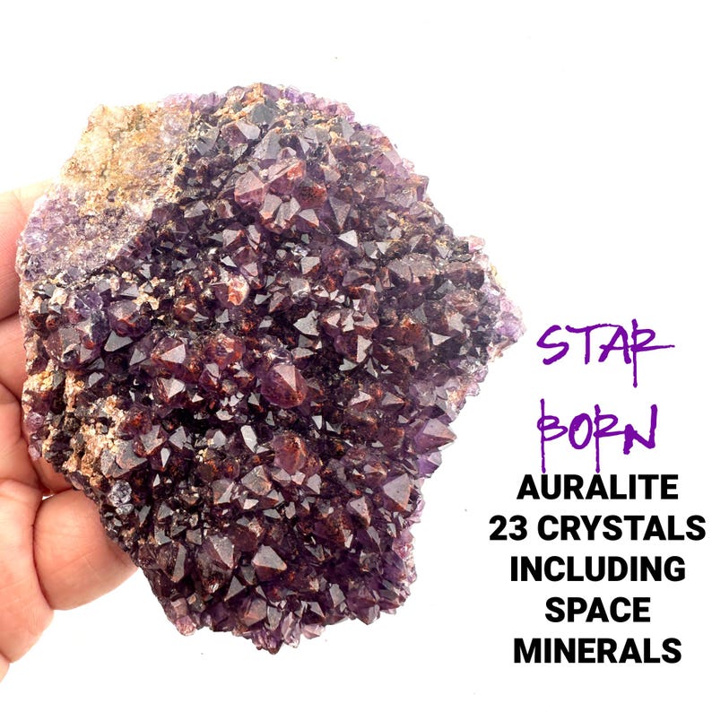 May include: A cluster of 23 purple and brown Auralite crystals, with the text "STAR BORN AURALITE 23 CRYSTALS INCLUDING SPACE MINERALS" visible in the image.