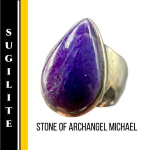 May include: A silver ring featuring a large, teardrop-shaped sugilite stone. The stone is a deep purple color with lighter purple and white marbling. The text "STONE OF ARCHANGEL MICHAEL" is below the ring.