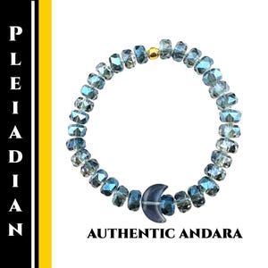 May include: A bracelet made of iridescent blue-green faceted beads, with a gold-coloured bead and a dark blue crescent moon charm. The text "AUTHENTIC ANDARA" is printed below. The bracelet is approximately 18 cm in circumference.