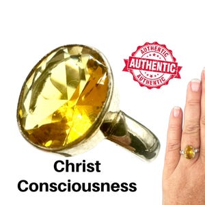 Op de afbeelding: Een zilveren ring met een grote, facetgeslepen gele edelsteen. De ring wordt getoond tegen een witte achtergrond, met de woorden "Christ Consciousness" eronder. Een rode "AUTHENTIC" stempel is ook zichtbaar.