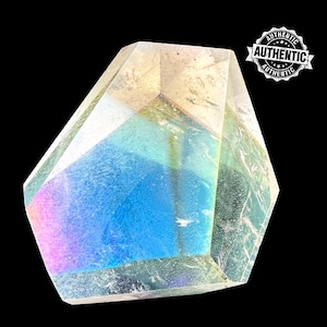 Puede incluir: Un cristal transparente iridiscente con una forma geométrica facetada. El cristal tiene un brillo arcoíris y es una opción popular para la curación con cristales y la meditación.