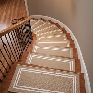 Puede incluir: Una escalera de madera curva con peldaños de alfombra color canela que presentan un diseño de borde rectangular blanco. La escalera incluye un pasamanos de madera con balaustres de metal negro y una lámpara colgante sobre los escalones.
