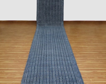 May include: A long, narrow blue and white runner rug with a geometric pattern. The rug has a white border and a repeating diamond pattern in the center.