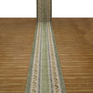 Könnte beinhalten: Ein langer, grüner und beiger Läufer mit einem Blumenmuster. Der Läufer hat einen Rand aus schwarzen und weißen geometrischen Mustern.