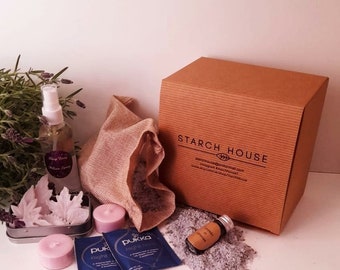 May include: A brown cardboard box with the text "STARCH HOUSE" printed on the top. The box contains a lavender-themed relaxation kit with a spray bottle, bath salts, candles, and a small pouch of lavender.