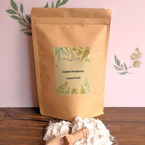 May include: A brown paper bag with a white label that says "Starch House" and "Carpet Freshener Lemon Fresh". The bag is open and a white powder is spilling out. A wooden scoop is next to the powder.