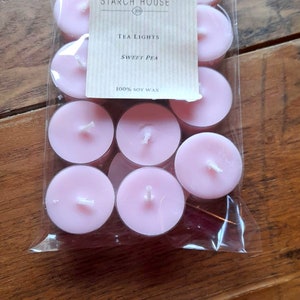May include: A package of pink tea lights with a label that reads "Starch House" and "Tea Lights Sweet Pea 100% Soy Wax".