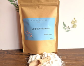 May include: A brown paper bag with a white label that says "Starch House" and "Carpet Freshener" in black text. The label also says "Fresh Linen" and "500gm". A wooden scoop is in a pile of white powder on a wooden surface.