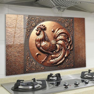 Puede incluir: Un protector de salpicaduras de cocina decorativo con un diseño de gallo de color cobre. El gallo está rodeado de intrincados patrones florales y se coloca sobre un fondo de cobre texturizado.