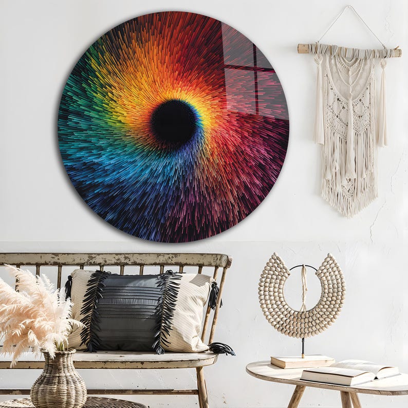 May include: A round wall art piece with a vibrant, swirling design in a spectrum of colors, including red, orange, yellow, green, and blue. The artwork has a central black hole effect, creating a sense of depth and movement. The piece is mounted on a white wall.