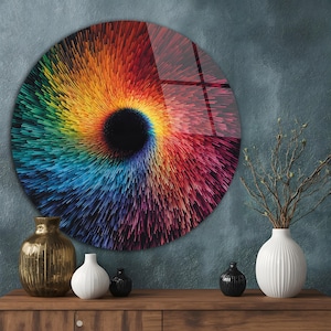 May include: A round wall art piece with a vibrant, swirling design in a spectrum of colors, from red and orange to blue and green. The artwork has a central black void, creating a dynamic, eye-catching visual effect. The art piece is displayed on a wall.