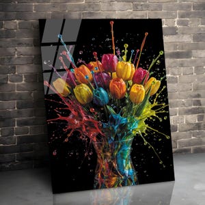 May include: A colourful art print showing a bouquet of tulips in a glass vase against a black backdrop. The tulips are painted in shades of yellow, orange, red, purple, and blue, with paint splashes adding a dynamic effect. The artwork is displayed on a wall.