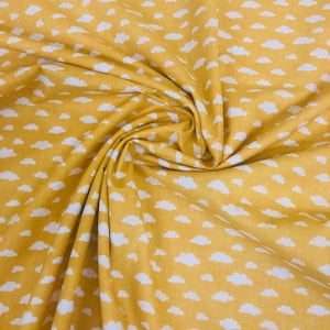 Mini clouds white on ochre yellow . 100% cotton fabric  , sold per metre or half metre , wide roll 160cm wide