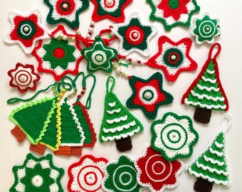 May include: A selection of handmade crochet Christmas decorations in red, green, and white. The ornaments include stars, Christmas trees, and circular designs, all with pearl accents. Some are strung together as garlands.